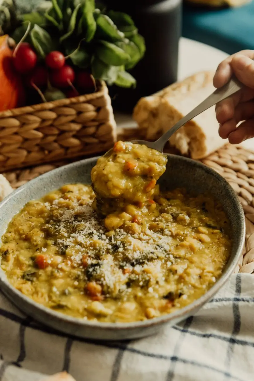 A bowl of hearty lentil and vegetable soup with a spoon