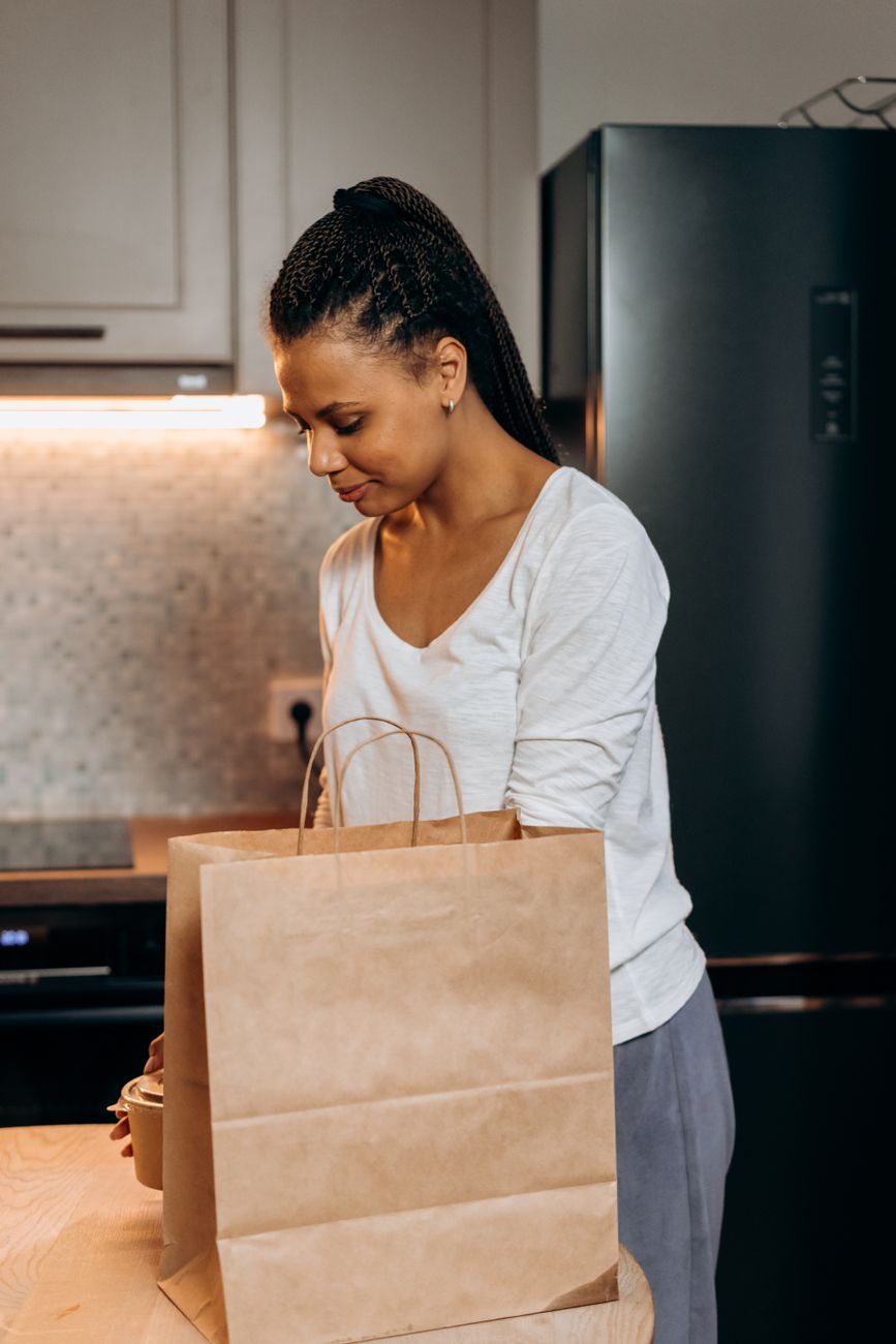 beginner packing portioned lunch meal prep containers into a bag for work