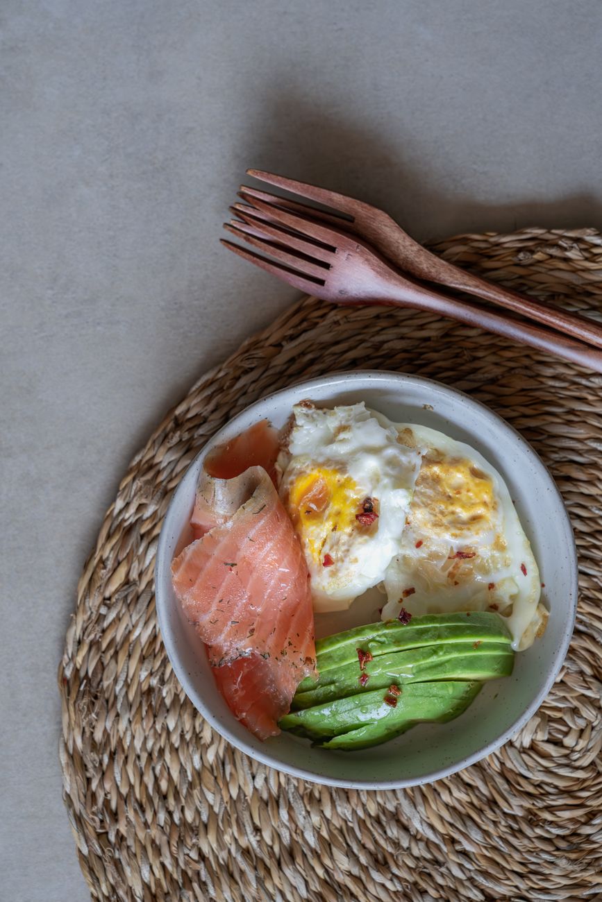 low carb meal prep bowl with salmon avocado and greens