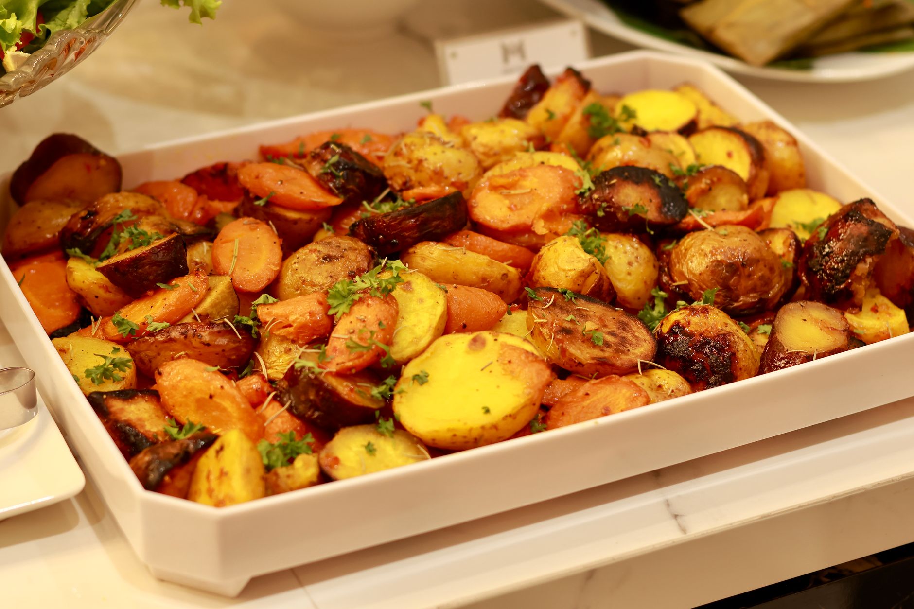 roasted potatoes and carrots in a baking tray for budget meal prep