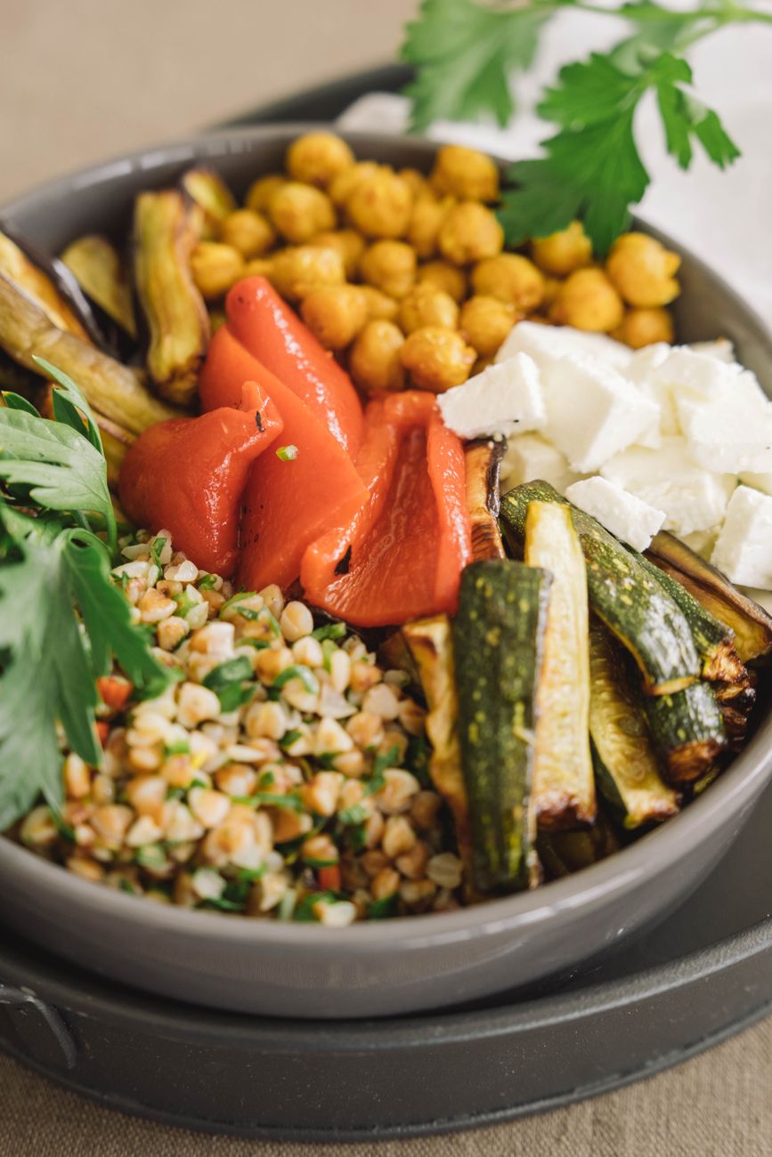 easy vegetarian meal prep grain bowl with chickpeas roasted vegetables and tahini sauce